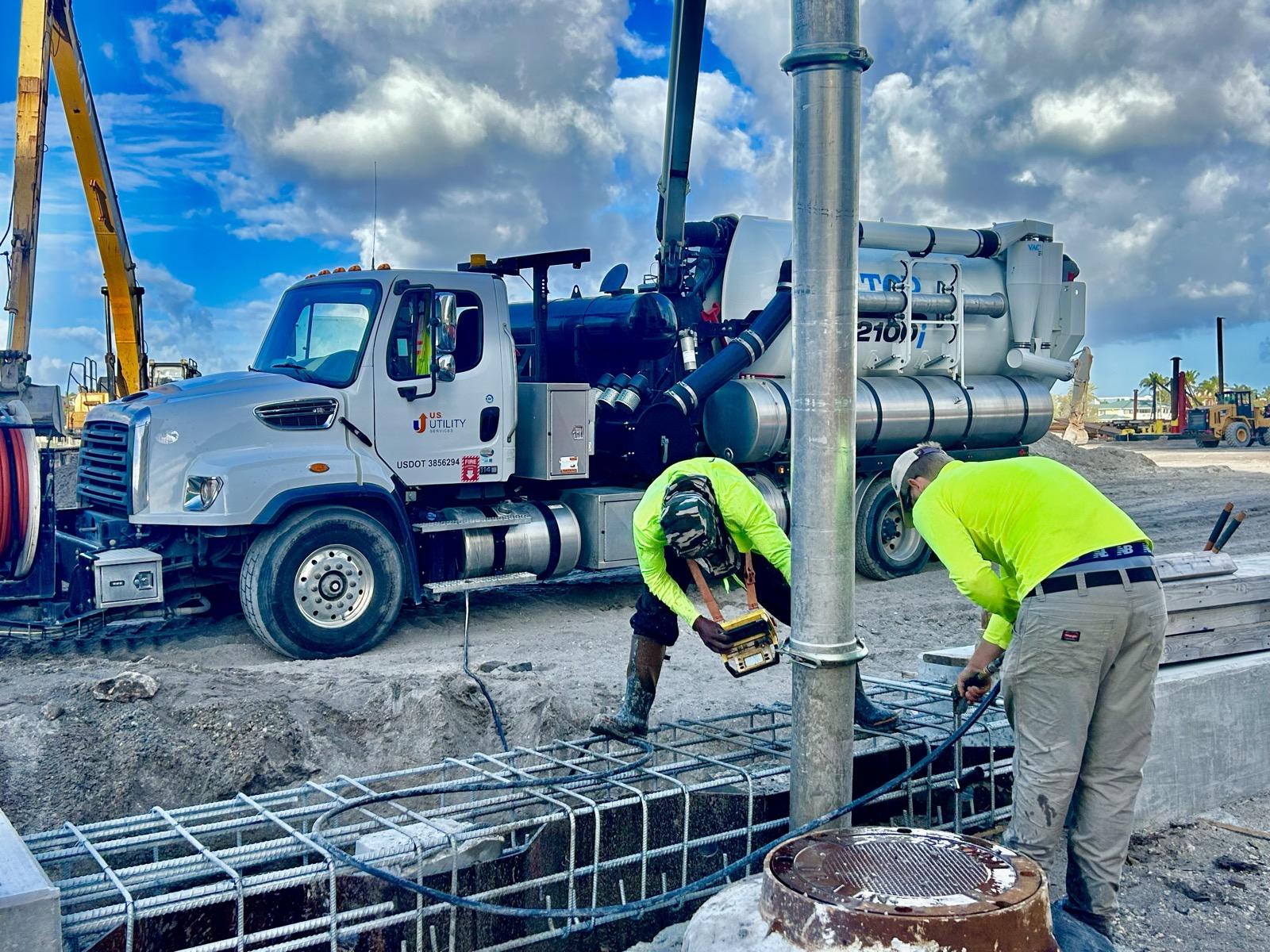 US Utility Services vac truck and crew performing soft dig excavation around rebar foundations on a South Florida construction site